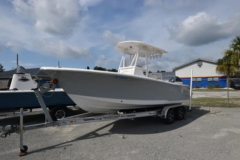 The Image of 2023 Sea Hunt Ultra 229 boat on trailer, parked outdoors under cloudy sky. - 0