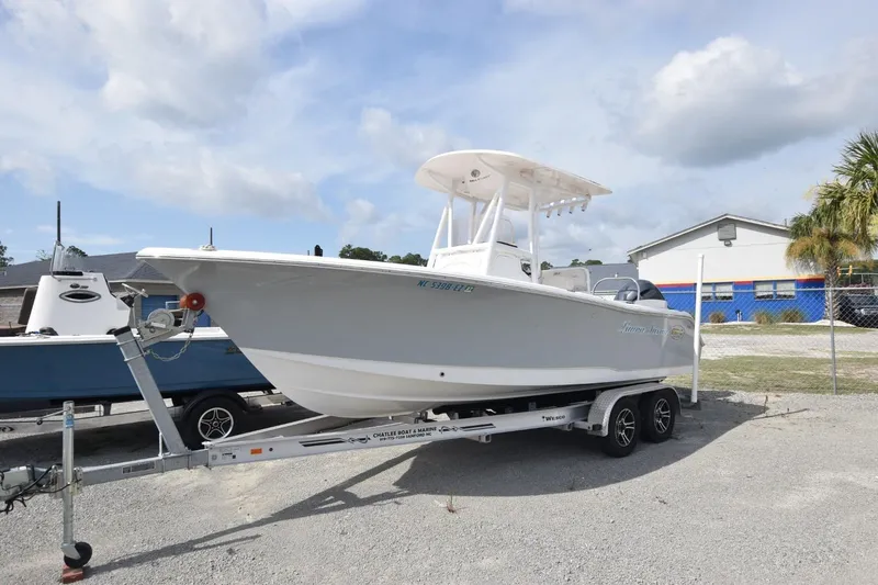 Slide: The Image of 2023 Sea Hunt Ultra 229 boat on trailer, parked outdoors under cloudy sky. - 1