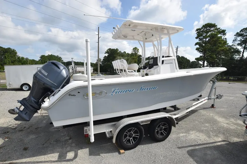 Slide: The Image of 2023 Sea Hunt Ultra 229 boat on trailer with Yamaha engine, parked outdoors. - 13