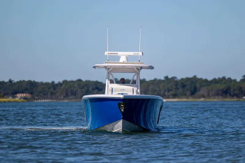 Slide: The Image of 2022 Blackwater 36 Sport boat cruising on a calm lake with forested shoreline. - 45