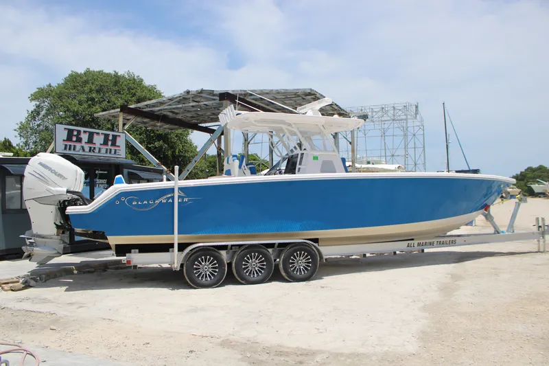 Slide: The Image of 2022 Blackwater 36 Sport boat on trailer at BTH Marine, featuring blue hull. - 37