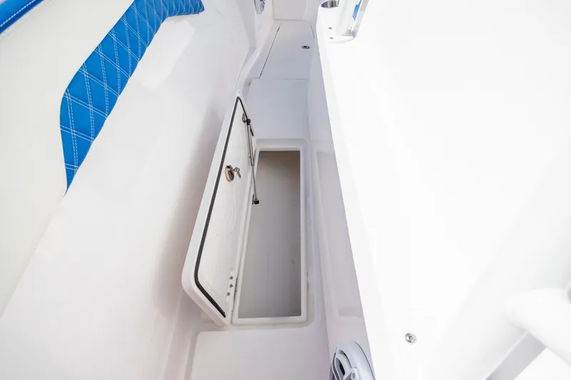Slide: The Image of Open storage compartment on 2022 Blackwater 36 Sport boat with blue seating. - 33