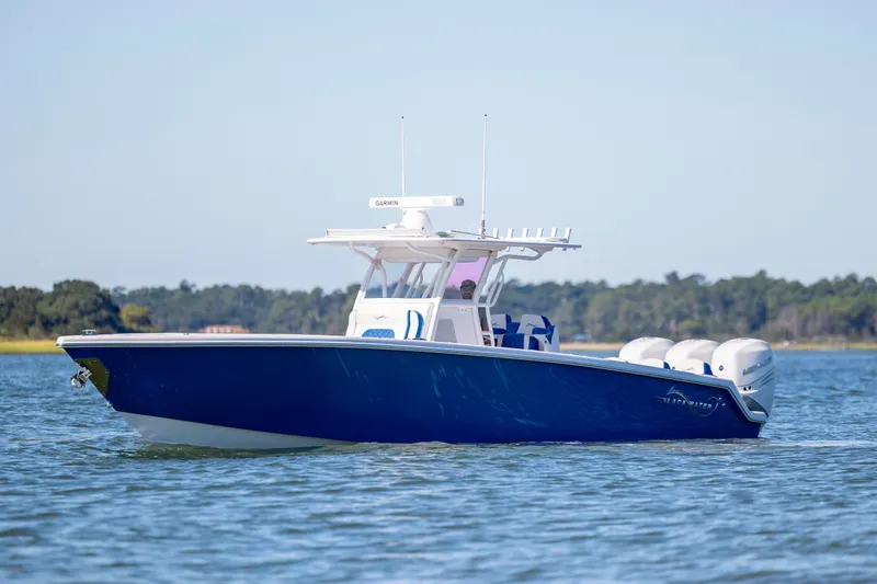 Slide: The Image of 2022 Blackwater 36 Sport boat on calm water, featuring sleek blue design and powerful engines. - 46