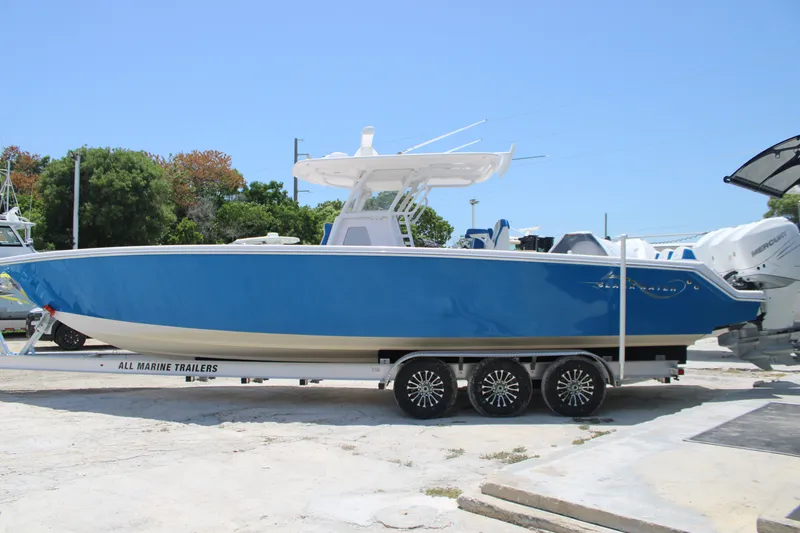 Slide: The Image of 2022 Blackwater 36 Sport boat on trailer, vibrant blue hull, parked outdoors. - 39