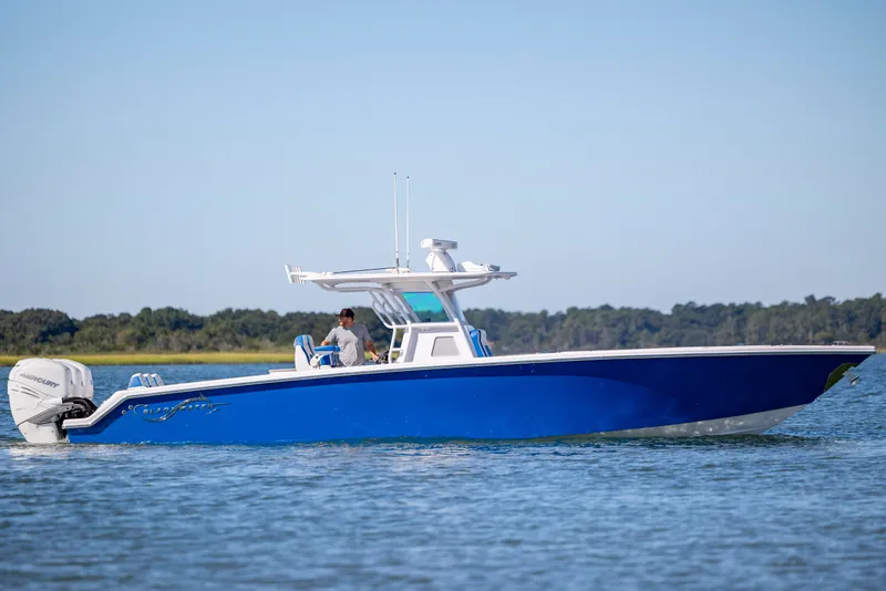 Slide: The Image of 2022 Blackwater 36 Sport boat cruising on a calm lake with scenic background. - 51