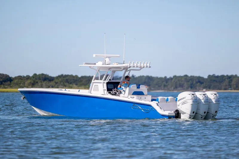 Slide: The Image of 2022 Blackwater 36 Sport boat with triple Mercury engines on calm water. - 48