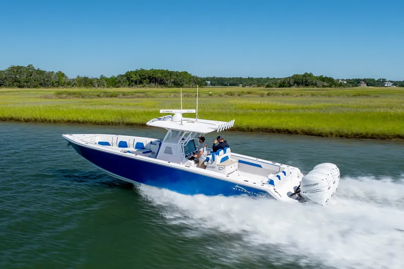 Slide: The Image of 2022 Blackwater 36 Sport boat cruising on a scenic waterway with lush greenery. - 52