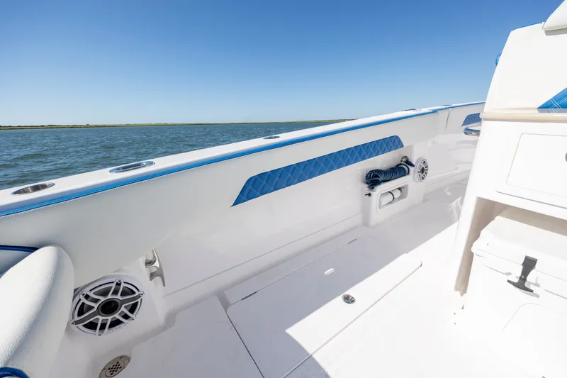Slide: The Image of 2022 Blackwater 36 Sport boat interior with blue accents, ocean view, and clear sky. - 10