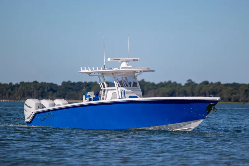 Slide: The Image of 2022 Blackwater 36 Sport boat cruising on calm water, featuring a sleek blue hull. - 44