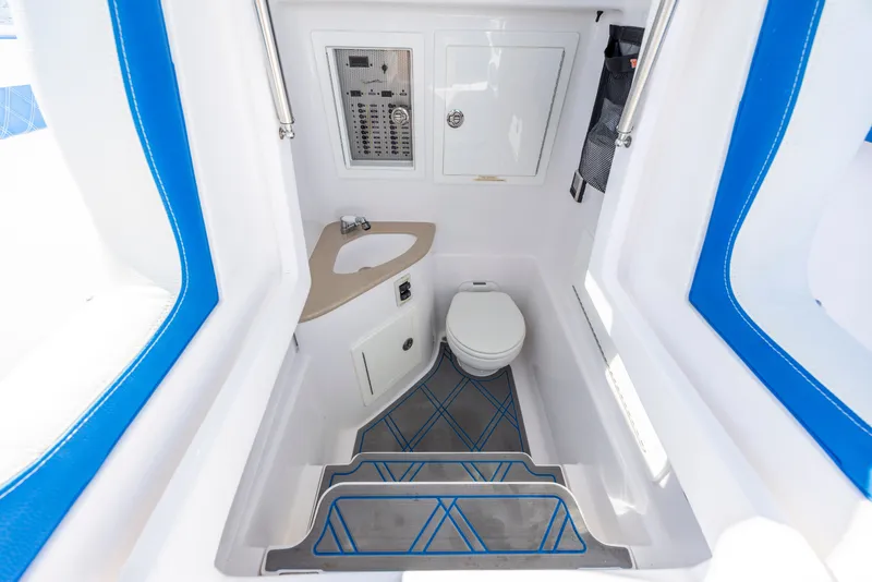 Slide: The Image of Interior of 2022 Blackwater 36 Sport boat featuring a compact bathroom with toilet and sink. - 21