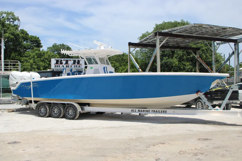 The Image of 2022 Blackwater 36 Sport boat on trailer, vibrant blue hull, parked outdoors. - 0