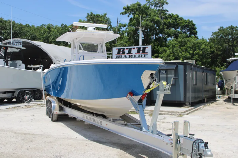 Slide: The Image of 2022 Blackwater 36 Sport boat on trailer at BTH Marine, surrounded by trees. - 2
