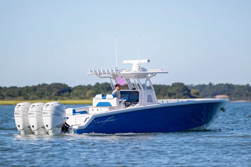 Slide: The Image of 2022 Blackwater 36 Sport boat with triple Mercury 400 engines cruising on water. - 50