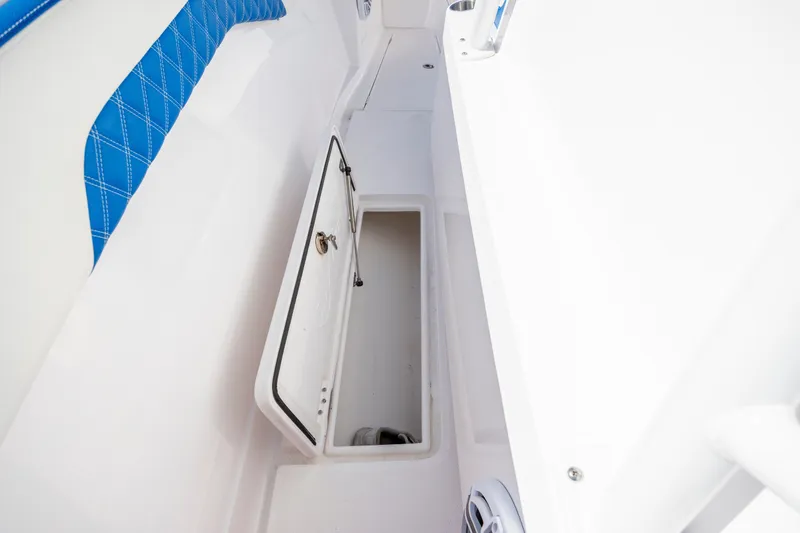 Slide: The Image of Interior storage compartment of 2022 Blackwater 36 Sport boat with blue cushioned seating. - 32
