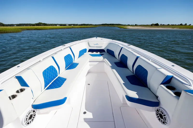 Slide: The Image of 2022 Blackwater 36 Sport boat with spacious seating, blue accents, and scenic water view. - 17