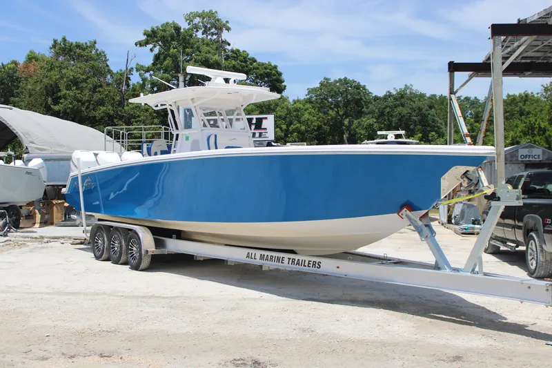 Slide: The Image of 2022 Blackwater 36 Sport boat on trailer, vibrant blue hull, parked outdoors. - 1