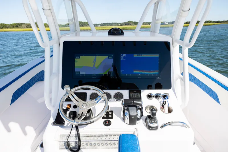 Slide: The Image of 2022 Blackwater 36 Sport boat dashboard with navigation screens and steering wheel on open water. - 13