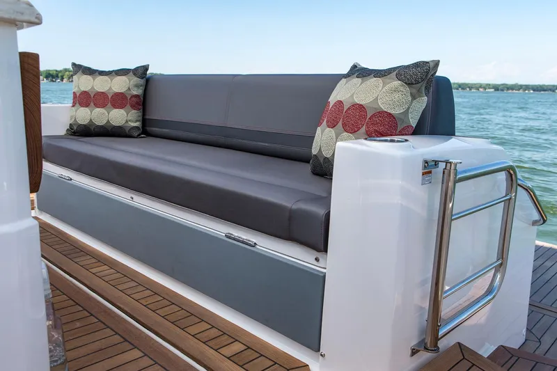 Slide: The Image of Manufacturer Provided Image: 2018 Tiara Yachts Q44 boat with cushioned seating and decorative pillows on deck. - 7