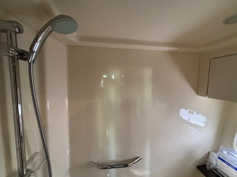 Slide: The Image of A shower cabin with a handheld showerhead and grab bar in a boat. - 24