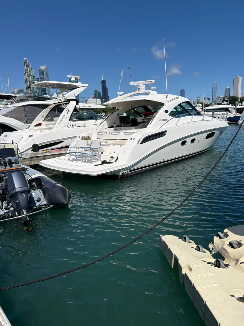 Slide: The Image of A white 2012 Sea Ray 470 Sundancer is docked in a marina. The skyline is visible in the background. - 36