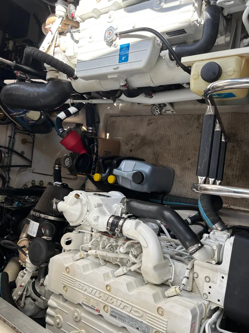 Slide: The Image of The engine room of a 2012 Sea Ray 470 Sundancer shows two large engines and various hoses. - 27