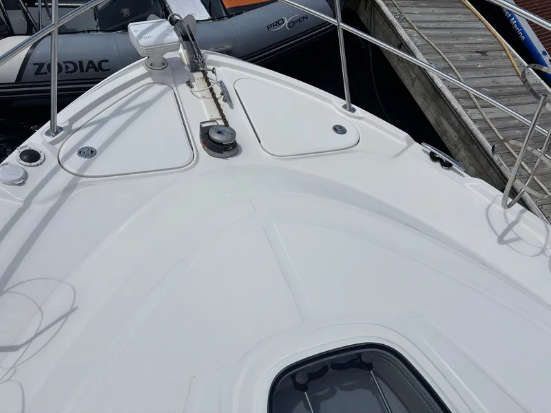 Slide: The Image of The bow of a 2012 Sea Ray 470 Sundancer, docked next to an inflatable boat. - 34