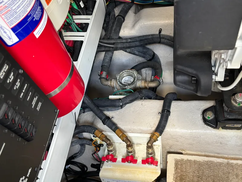 Slide: The Image of The engine room of a 2012 Sea Ray 470 Sundancer shows hoses, valves, and a fire extinguisher. - 30