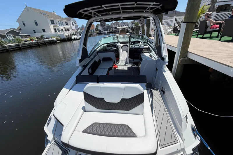 Slide: The Image of 2023 Monterey 305SS Super Sport boat docked by waterfront homes. - 11