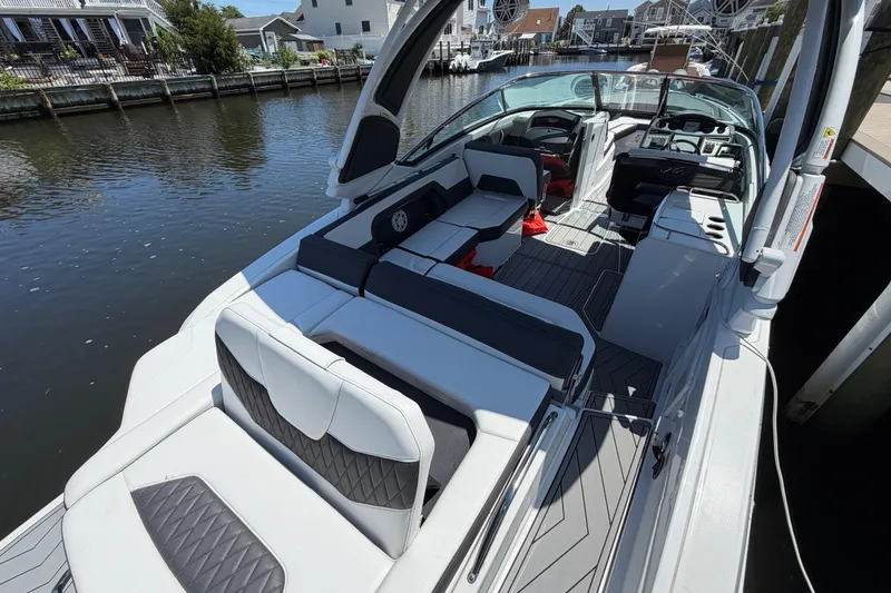 Slide: The Image of 2023 Monterey 305SS Super Sport boat with sleek interior design docked by the water. - 12