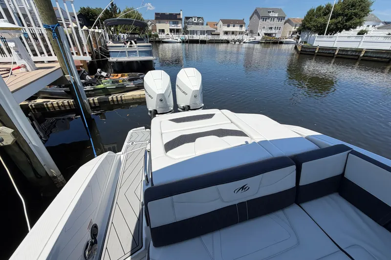 Slide: The Image of 2023 Monterey 305SS Super Sport boat docked in a serene residential canal. - 30