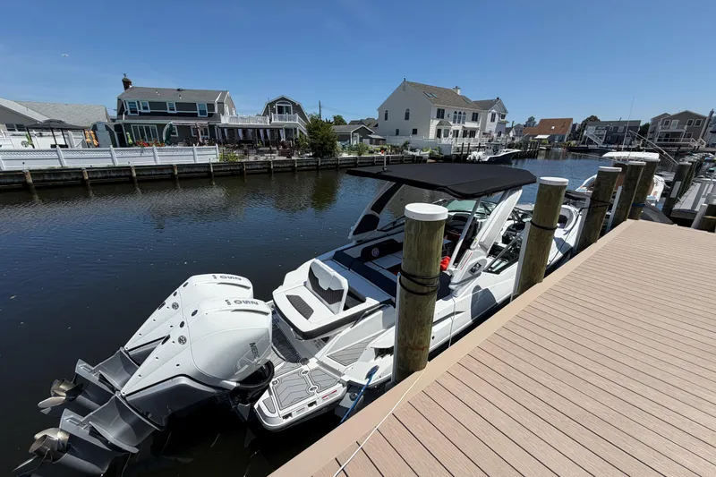 Slide: The Image of 2023 Monterey 305SS Super Sport boat docked in a scenic residential canal. - 47