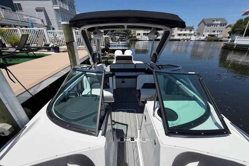 Slide: The Image of 2023 Monterey 305SS Super Sport boat docked in a scenic marina setting. - 35