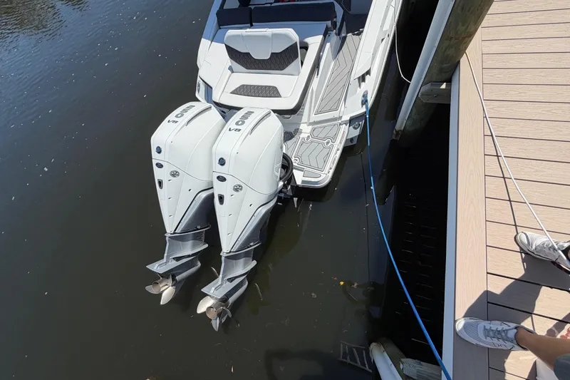 Slide: The Image of 2023 Monterey 305SS Super Sport boat with dual outboard engines docked on calm water. - 46