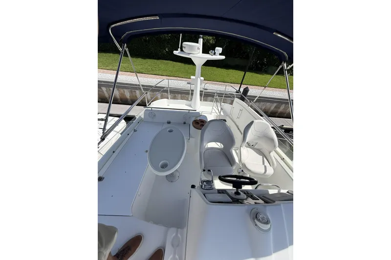 Slide: The Image of 2008 Beneteau Antares 13.80 yacht cockpit with seating and steering wheel under canopy. - 10