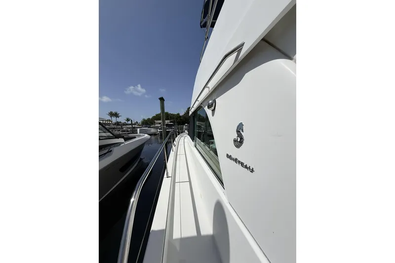 Slide: The Image of Side view of a 2008 Beneteau Antares 13.80 yacht docked under a clear blue sky. - 4