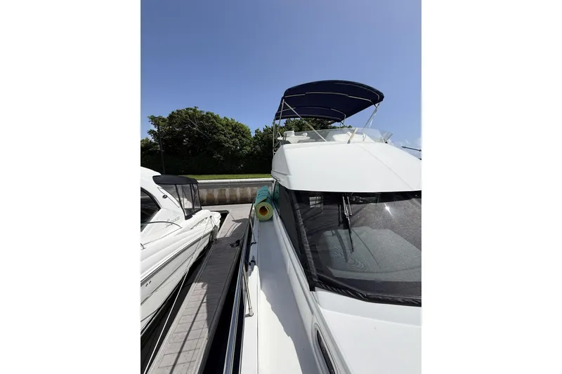 Slide: The Image of 2008 Beneteau Antares 13.80 yacht docked under clear blue sky. - 8