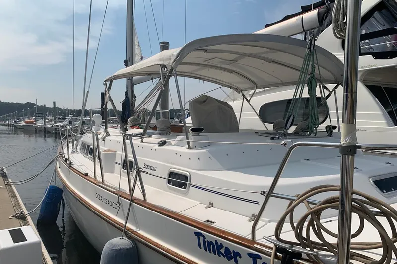 The Image of 1990 Beneteau Oceanis 390 sailboat docked at marina, featuring white hull and canopy. - 1