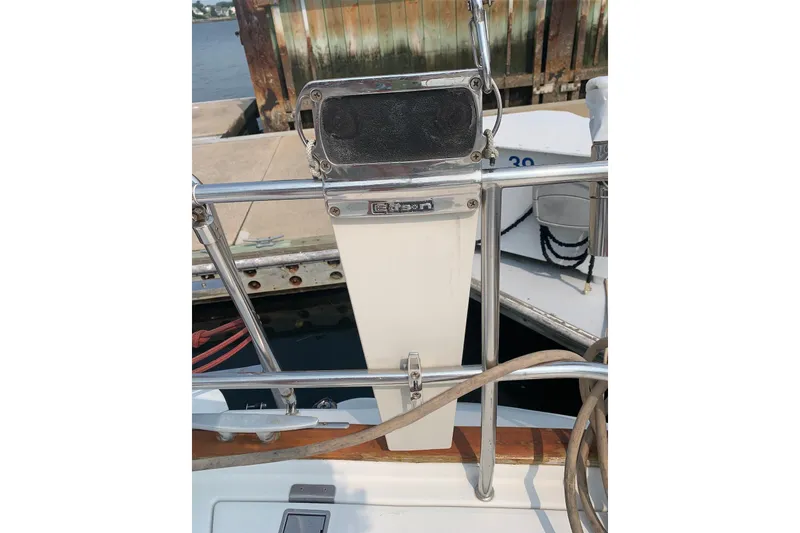 Slide: The Image of Beneteau Oceanis 390 sailboat detail, featuring a metal railing and dock background. - 72