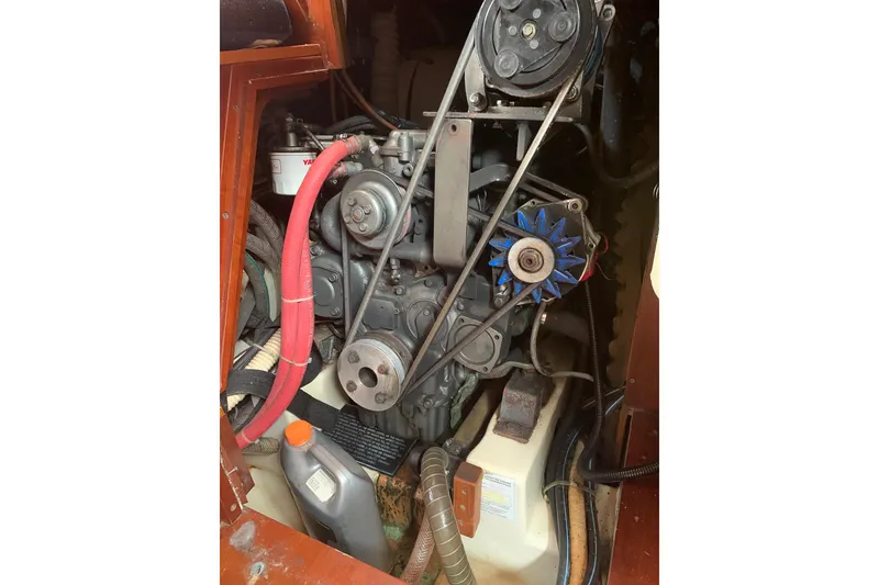 Slide: The Image of Engine compartment of a 1990 Beneteau Oceanis 390 sailboat, featuring visible belts and hoses. - 52