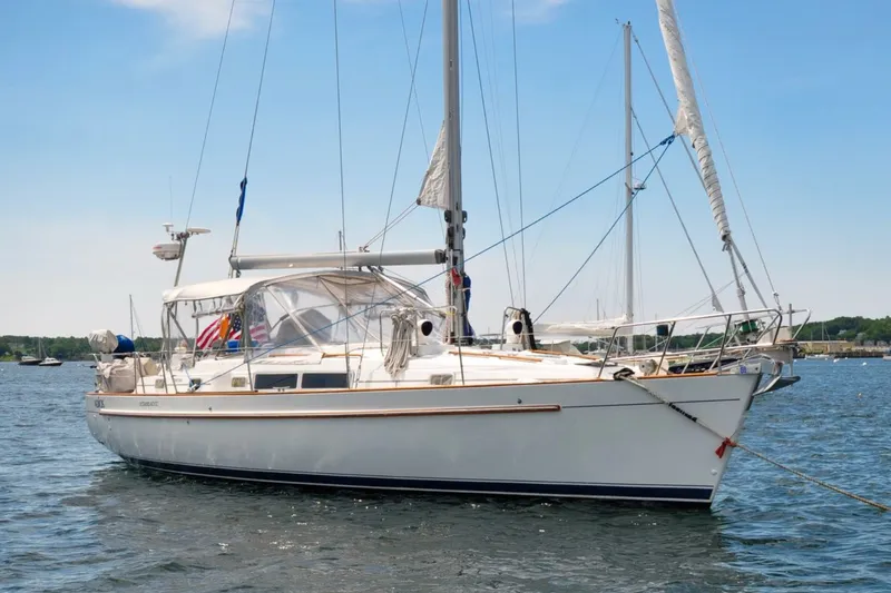 The Image of 1996 Beneteau Oceanis 40 CC sailboat anchored on calm water under a clear blue sky. - 0