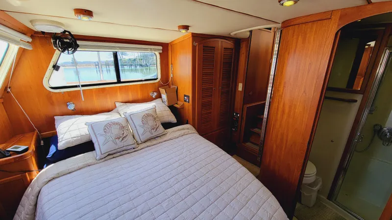 Slide: The Image of The image shows a cozy cabin with a double bed, wooden walls, and a window overlooking the water. - 34