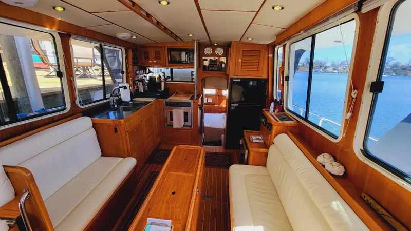 Slide: The Image of Interior of a 2003 Pacific Seacraft 38T Fast Trawler with wood furnishings and white upholstery. - 9