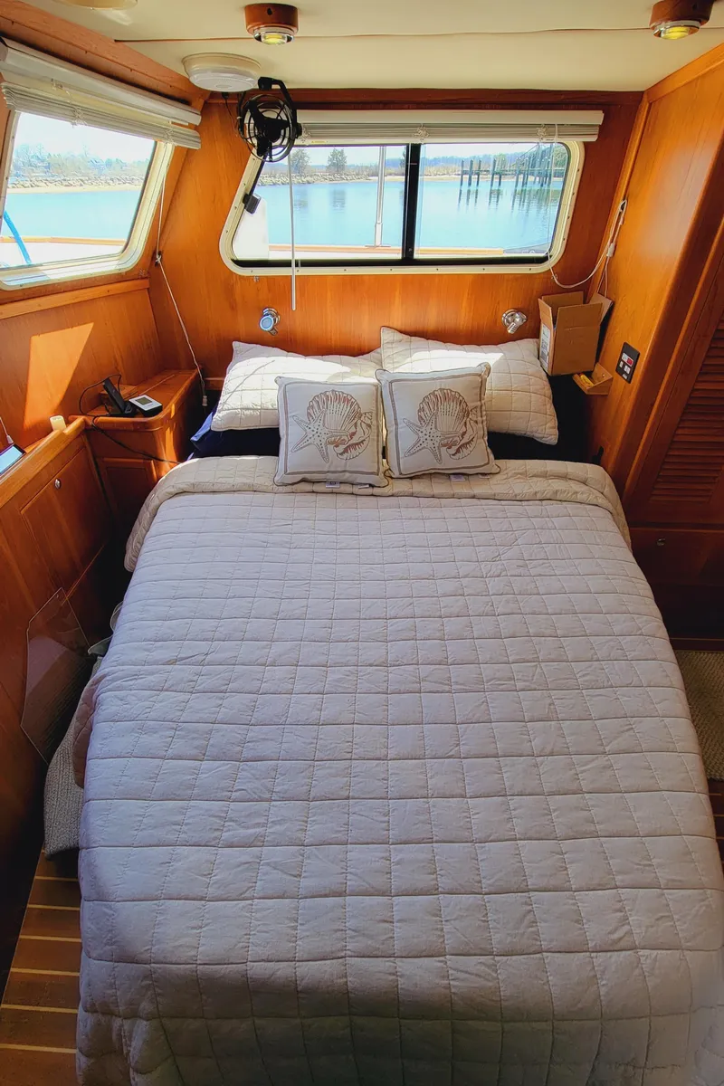 Slide: The Image of The image shows a cozy bedroom on a boat with a large bed and wooden walls. - 33
