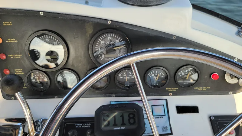 Slide: The Image of The dashboard of a boat with multiple gauges and a steering wheel. - 38