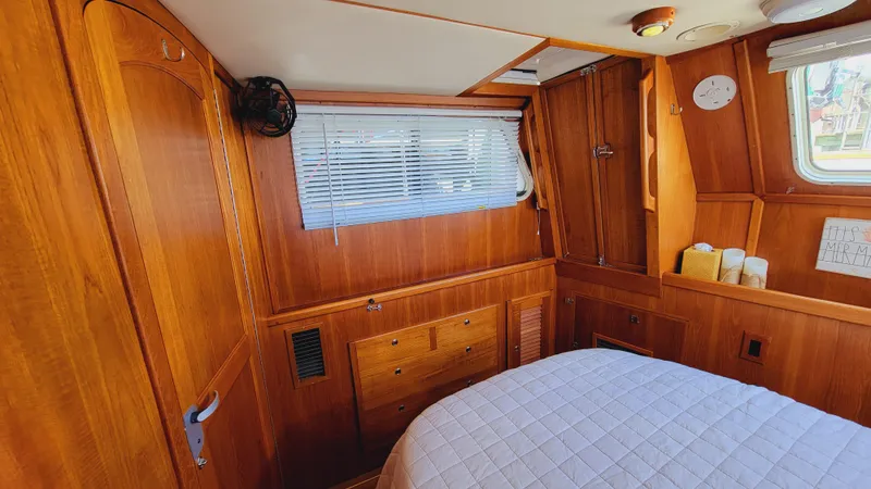 Slide: The Image of The cabin of a 2003 Pacific Seacraft 38T Fast Trawler with wooden furnishings and a bed. - 30