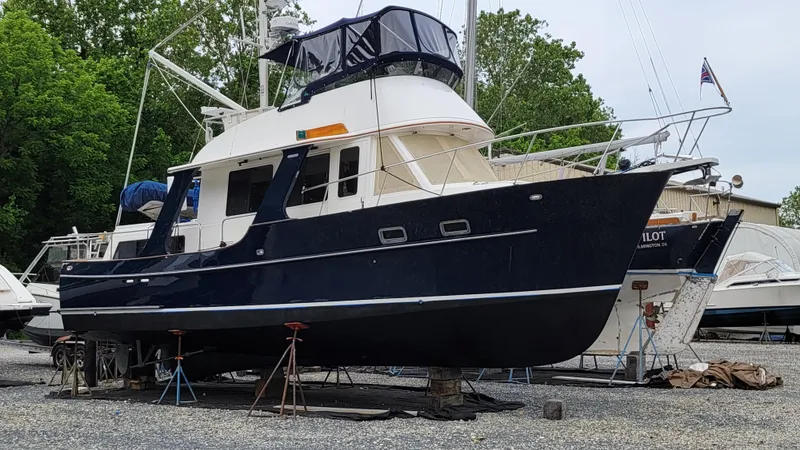 Slide: The Image of A 2003 Pacific Seacraft 38T Fast Trawler is on a dry dock, surrounded by trees. - 2