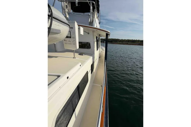 Slide: The Image of 2003 Pacific Seacraft 38T Fast Trawler on calm water, showcasing sleek deck design. - 124