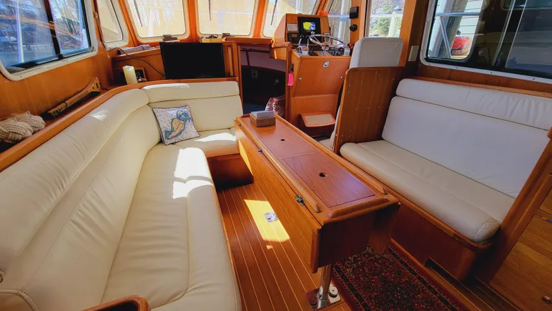 Slide: The Image of Interior of a 2003 Pacific Seacraft 38T Fast Trawler with white leather sofas and wooden flooring. - 5