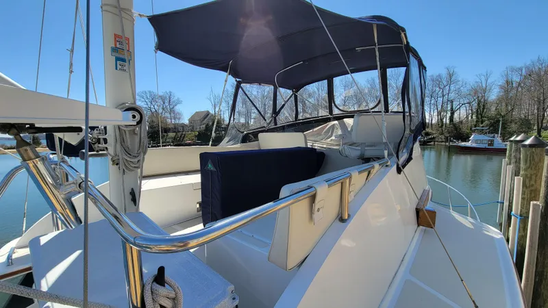 Slide: The Image of A 2003 Pacific Seacraft 38T Fast Trawler with a blue sunshade, docked at a marina. - 13