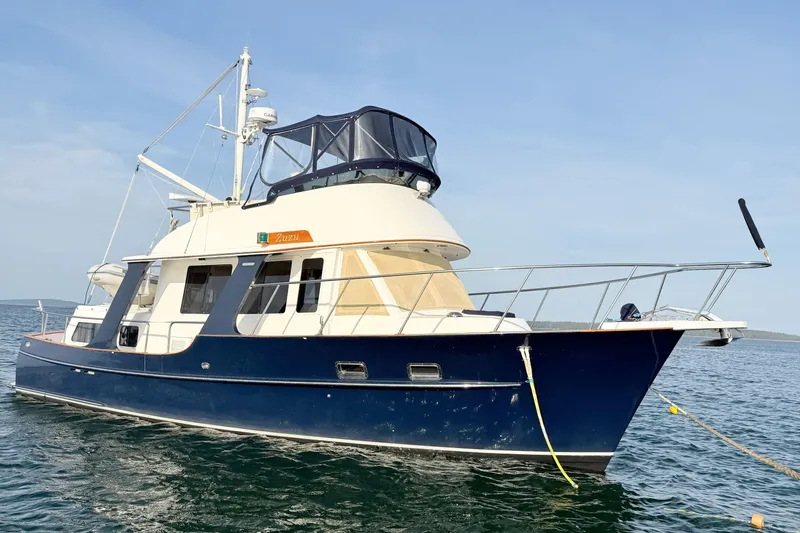 Slide: The Image of 2003 Pacific Seacraft 38T Fast Trawler on calm water, featuring a sleek blue hull. - 123